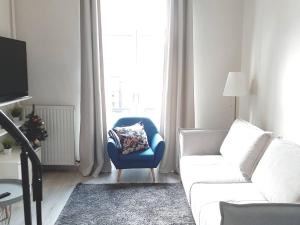 a living room with a couch and a chair and a window at Superbe appartement au coeur du quartier européen in Brussels