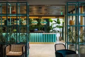 a lobby with plants and a waiting area at Khedi Hotel by Ginza Project in Tbilisi City