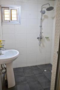 a white bathroom with a shower and a sink at Tulsa Home - Douala - Bonamoussadi - Wifi - Canal+ in Douala