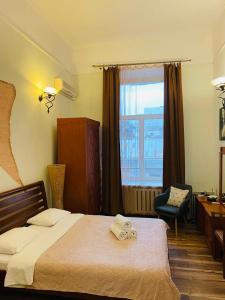 a bedroom with a bed and a desk and a window at Real Home Apartments in Kiev Center in Kyiv