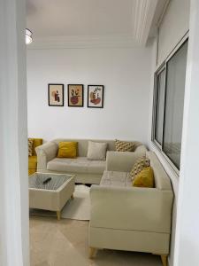uma sala de estar com dois sofás e uma mesa em Lovely 1-bedroom rental unit with sea view em Mahdia