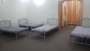 a group of four beds in a room at Residency Girls Hostel - For Females Only in Lahore