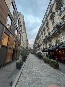 New Entiry apartment-Private rooms in Paris في باريس: شارع فاضي في مدينه فيها مباني طويله