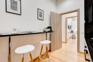 a kitchen with a counter and two stools in a room at Vatican Prestige Apt by Premium Suites Collection in Rome +29 photos
