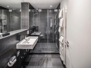 ein Bad mit 2 Waschbecken und einer Dusche in der Unterkunft Boarding World smart Hotel in Mannheim