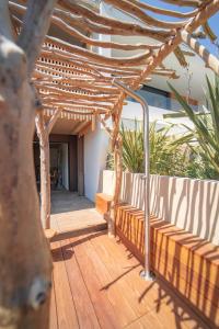 una terraza de madera con pérgola en una casa en Villa Ananda - Chandra - Un havre de paix entre mer et étangs en Carnon-Plage