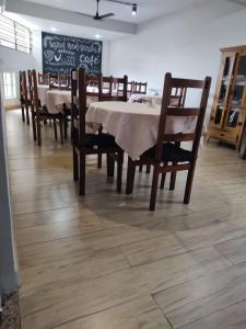 a dining room with a table and chairs and a chalkboard at Hotel Village Cataguases in Cataguases