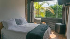 a bedroom with a bed and a large window at Pousada Monttana in Lavras Novas