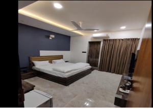 um quarto com uma cama e uma parede azul em Hotel Riya Imperial By WB Inn em Gondia