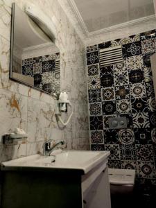 a bathroom with a sink and black and white tiles at Hotel Anibal in Gebze