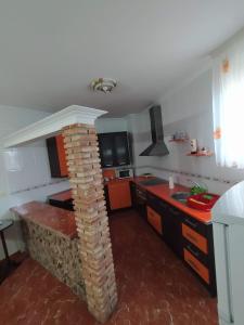 a kitchen with a brick pillar in the middle at Pililla in Bedmar +8 photos