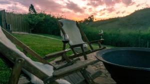 two chairs with wine glasses sitting next to a hot tub at Pousada Monttana in Lavras Novas