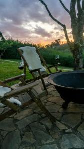 a chair sitting next to a tub on a stone patio at Pousada Monttana in Lavras Novas