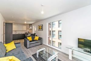 a living room with a couch and a tv at Halo Apartments - City Centre in Manchester
