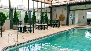 a pool with chairs and a table and a dining room at Pousada Monttana - By UP Hotel in Lavras Novas