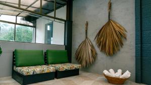 a living room with a green couch and a basket at Pousada Monttana in Lavras Novas