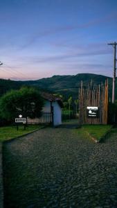 a fence with two signs on it next to a house at Pousada Monttana in Lavras Novas