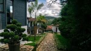 a cobblestone path between two houses with palm trees at Pousada Monttana in Lavras Novas