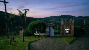 a gate to a house with a sign that says fun at Pousada Monttana in Lavras Novas