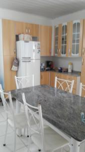kuchnia ze stołem z krzesłami i lodówką w obiekcie Casa Praia em Ingleses- Florianópolis w mieście Florianópolis