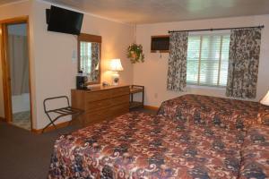 a hotel room with a bed and a television at The Village Motel in Richfield Springs