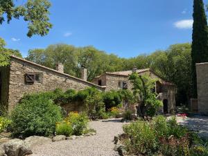 una casa de piedra con un jardín delante de ella en MAS DEL CA Adult Only en Sorède