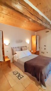 een slaapkamer met een groot bed en een houten plafond bij Gîte Laguës in Poueyferré