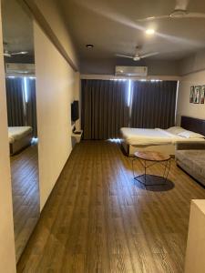 Zimmer mit 2 Betten und einem Tisch in der Unterkunft Weekend address homestay by shan in Surat