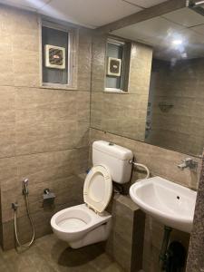 une salle de bain avec toilettes et lavabo dans l'établissement Weekend address homestay by shan, à Surate