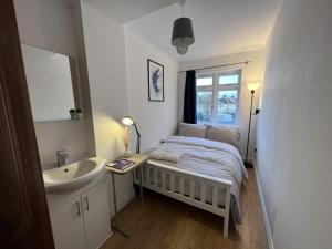 a small bedroom with a bed and a sink at 4 Wharncliffe Drive in Hanwell