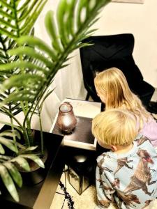 zwei Kinder, die an einem Tisch mit einem Laptop sitzen in der Unterkunft Die Ibbenbürener Ferienstube in Ibbenbüren
