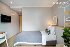 um quarto com uma cama e um sofá branco em GROOVE AT SIAM em Pom Prap