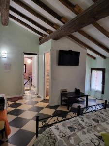 un salon avec un lit et une télévision sur un mur dans l'établissement A casa di luca, à Mediglia