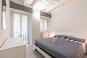 a white bedroom with a bed and two windows at Palazzetto Vittoria - F&L Apartment in Brescia