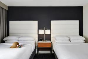 Hotel Tampa Riverwalk في تامبا: سريرين يجلسون بجانب بعض في غرفة