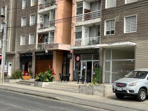Un coche aparcado en una calle frente a un edificio. en Casa Alameda Remodelada, en Constitución