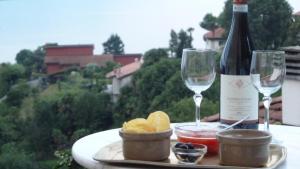 a table with a bottle of wine and two glasses at B&B Casa Forster in Cannero Riviera
