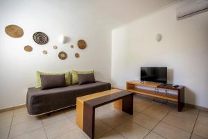 a living room with a couch and a tv at Aquamar Albufeira Aparthotel in Albufeira