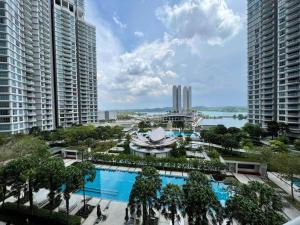 una vista aérea de una piscina en una ciudad con edificios altos en Teega Suites Puteri Harbour Iskandar Puteri #PoolView SeaView en Nusajaya