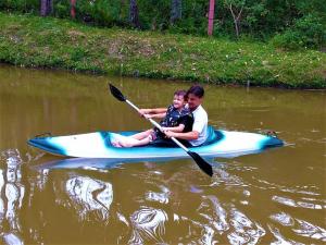 a man and a boy on a kayak in the water at Sitio Libardo em Meio a Natureza - Nova Trento in Nova Trento