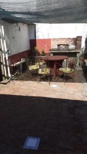 un patio con mesa, sillas y piano en LA CASA DE LOS OLMITOS, en Punta del Este
