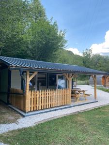 einen Pavillon mit einem Picknicktisch und einem Zaun in der Unterkunft TOP rafting center in Bovec