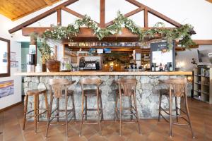 un bar con sgabelli di fronte a un bancone di REFUGE- GITE Le Pas de l'Ane a Villar-dʼArène