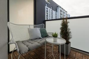 華沙的住宿－Spacious Apartment Premium Warszawa Wola by Renters Prestige，一张白色长凳,坐在带桌子的阳台