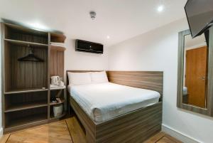 a small bedroom with a bed and a mirror at The Podworks Hotel in Liverpool