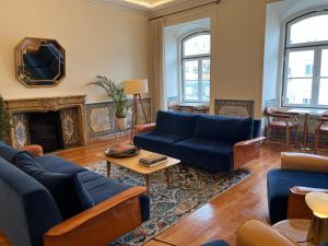 a living room with blue couches and a fireplace at Memoria Lisboa FLH Hotels in Lisbon