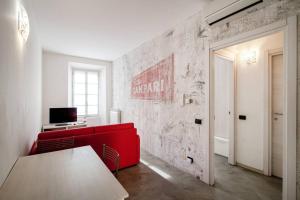 a living room with a red couch and a table at Be Happy - The House Of Travelers in Como