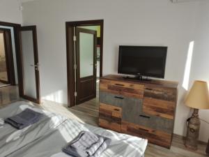 um quarto com uma televisão de ecrã plano e uma cama em Апартамент Рая 2 em Dobrich