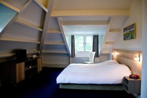 een slaapkamer met een groot wit bed en een raam bij Hotel-Restaurant Het Rechthuis in Muiderberg +37 foto's