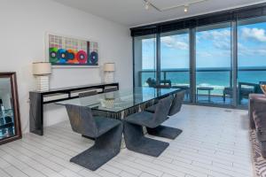 comedor con mesa de cristal y sillas en Oceanfront Private Residence at W South Beach -828, en Miami Beach